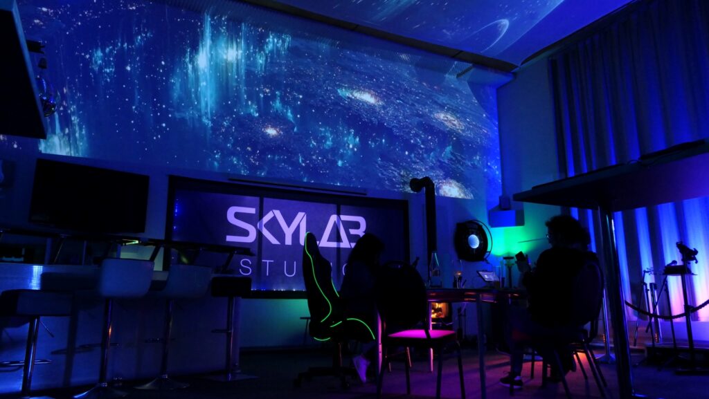 Studio mit blauer Beleuchtung und Sternenhimmel-Projektion.